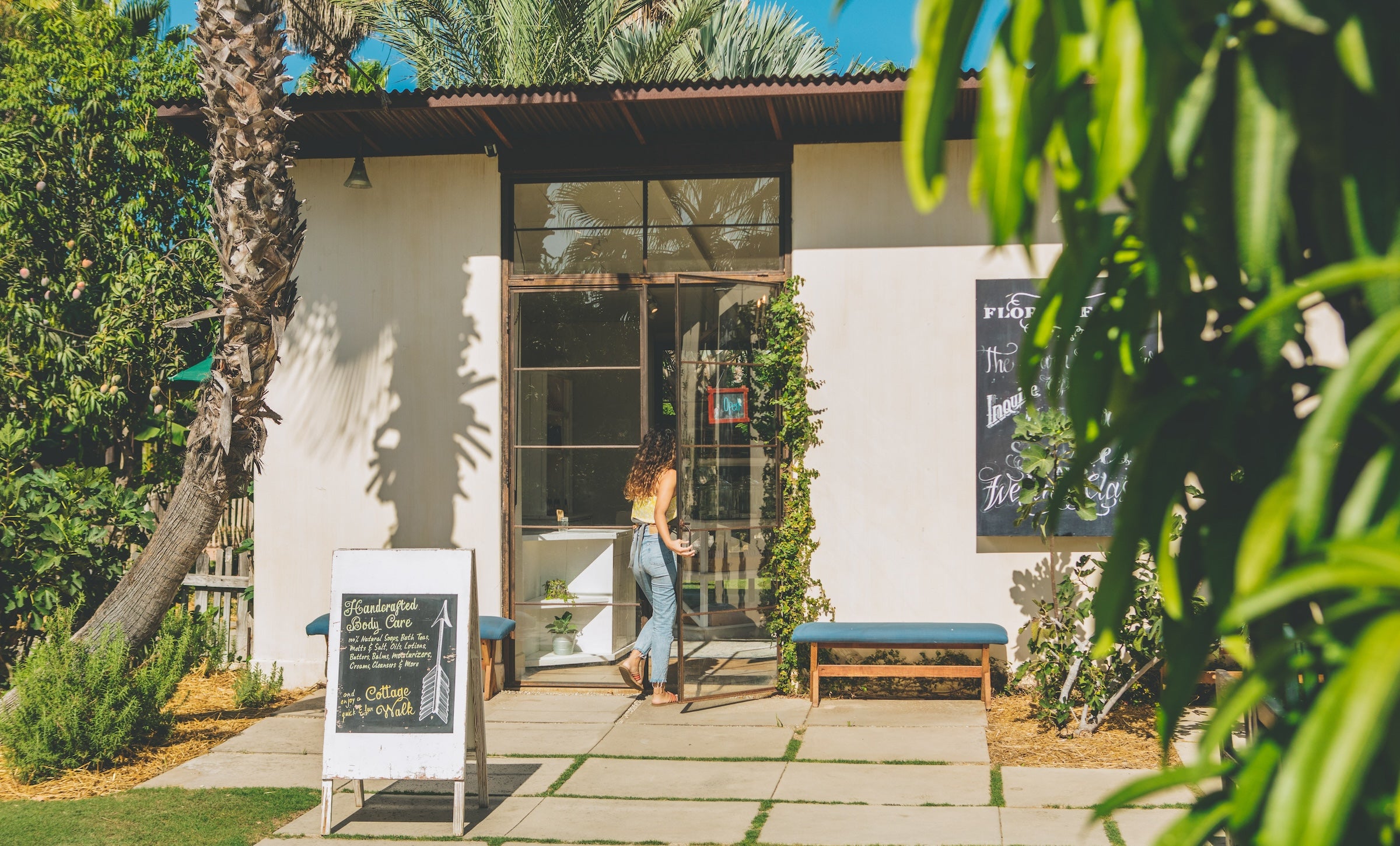 Girl in jeans walking in to Santo Cabo store at Flora Farms in San Jose del Cabo Mexico