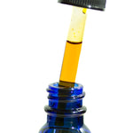 Close-up of the Age Care Facial Serum's golden, fast-absorbing oil being drawn into the dropper from the vibrant blue glass bottle, symbolizing the meticulous facial care routine offered by our vegan .5 oz serum, perfect for all skin types, especially those needing UV protection and anti-aging hydration.